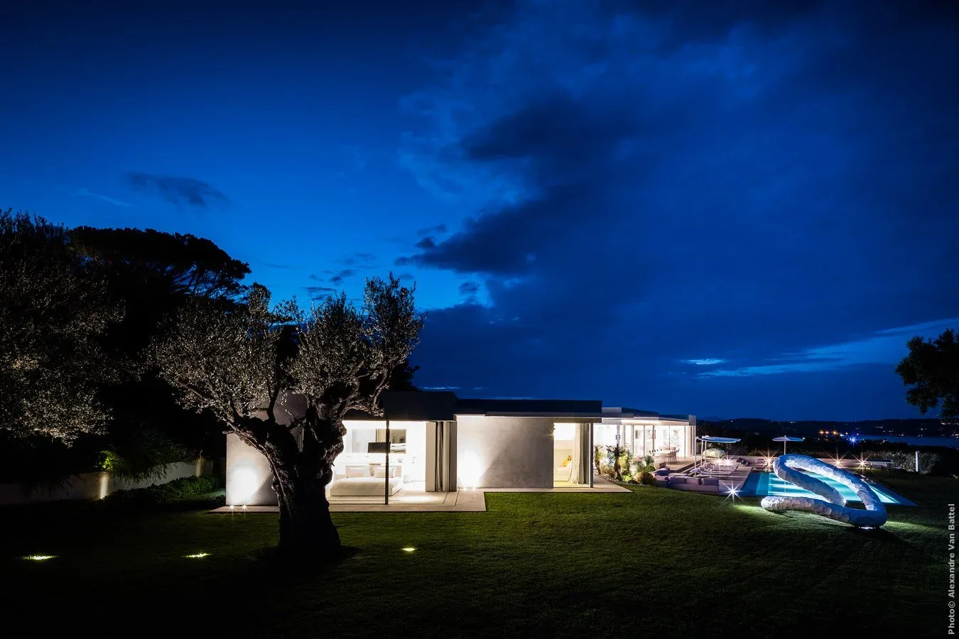 Façade illuminée et piscine de nuit