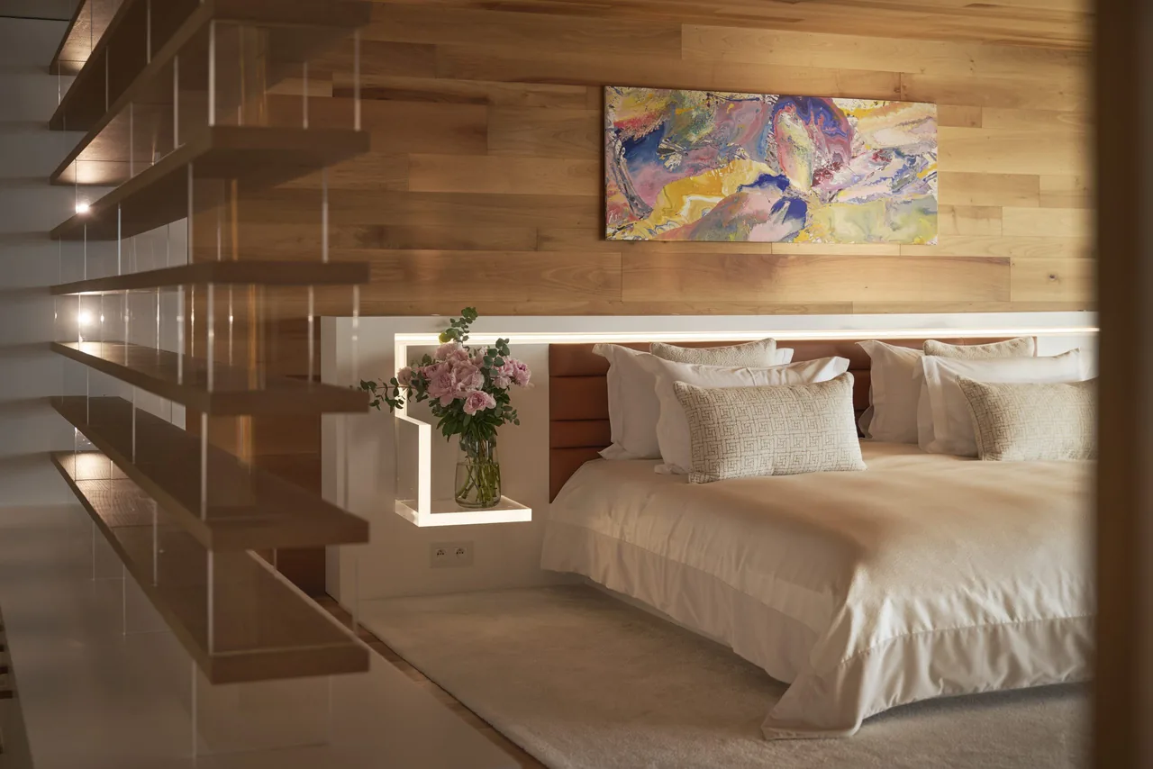 Chambre maître avec étagères design et tête de lit éclairée