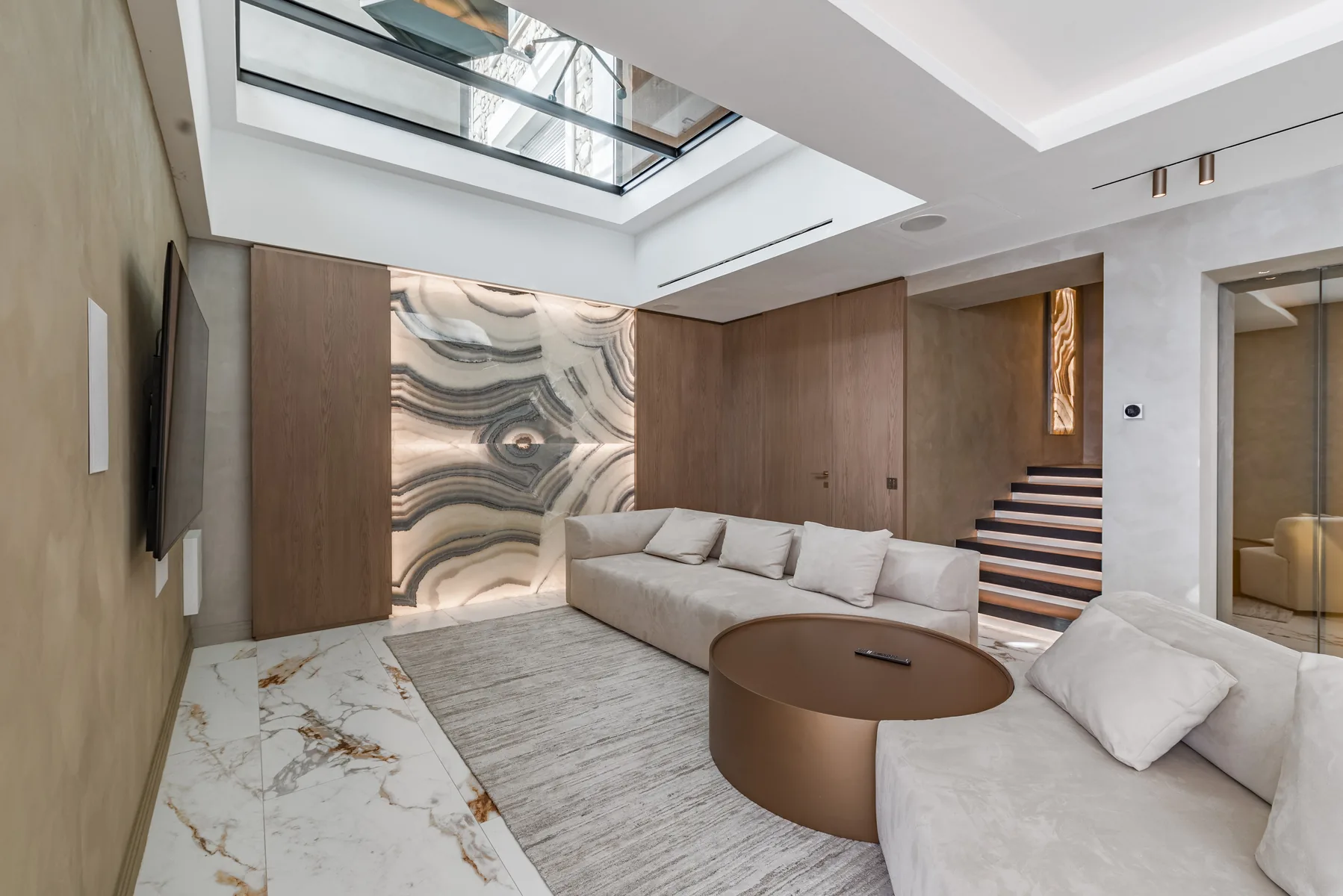 Salon familial avec mur d’onyx rétroéclairé et escalier en bois