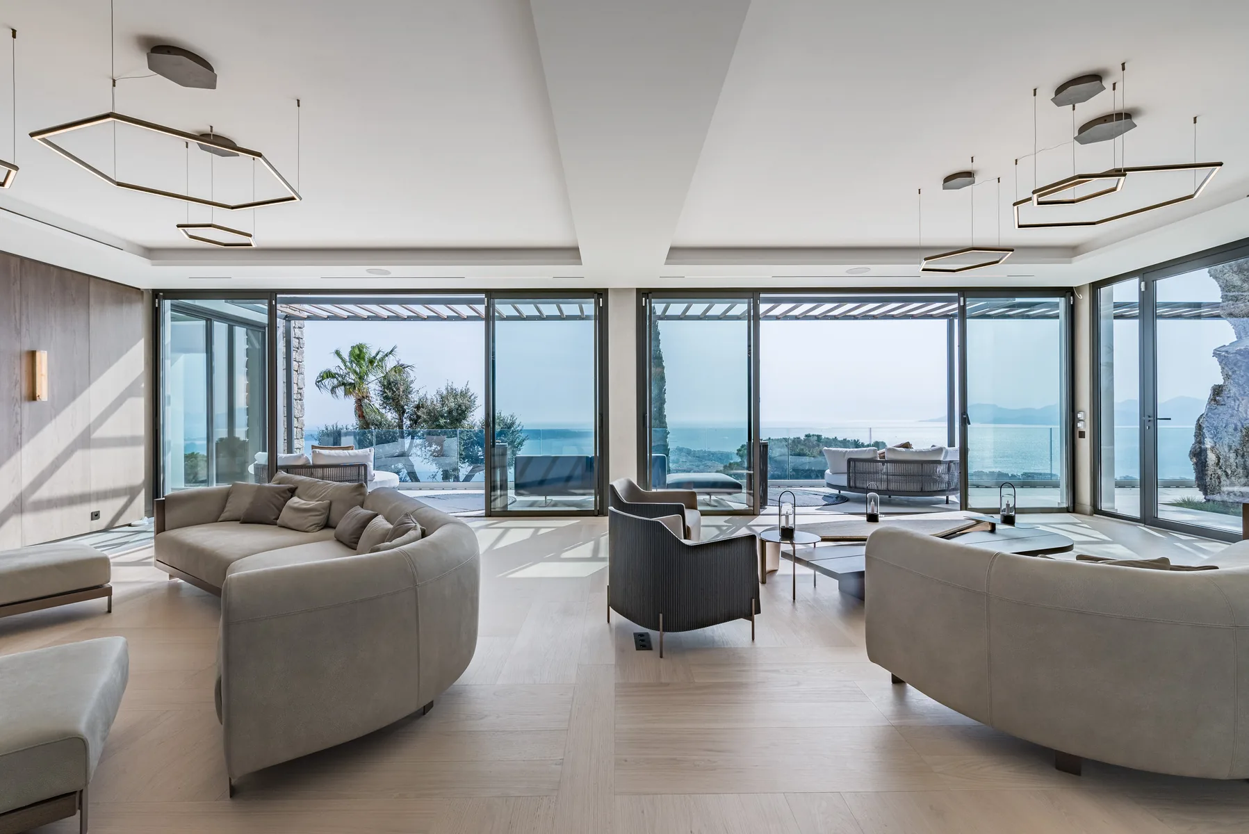 Second salon avec deux sofas courbes ouvert sur la terrasse mer
