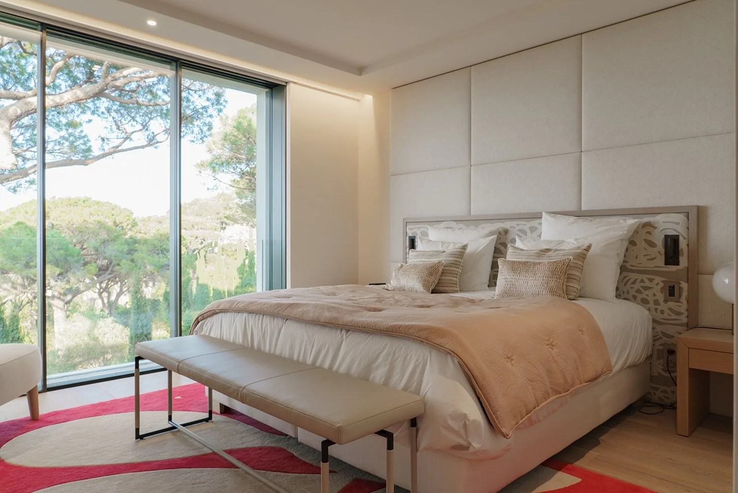 Chambre king tapis rose et baies vitrees vue pinede