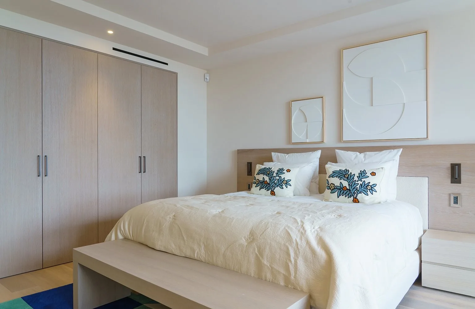 Chambre blanche avec dressing chene et coussins fleuris