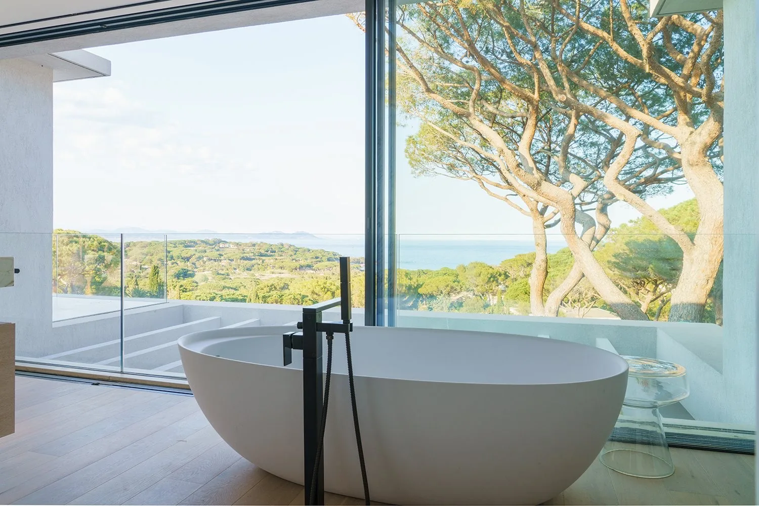 Salle de bain master baignoire ilot face mer et pins parasols