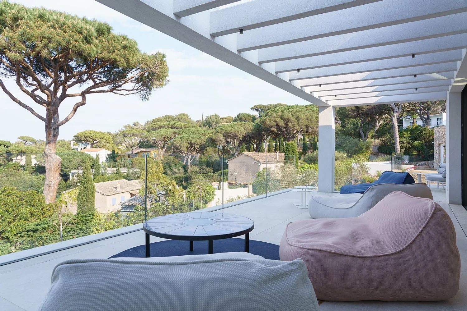 Terrasse lounge avec poufs et table mosaique sous pergola