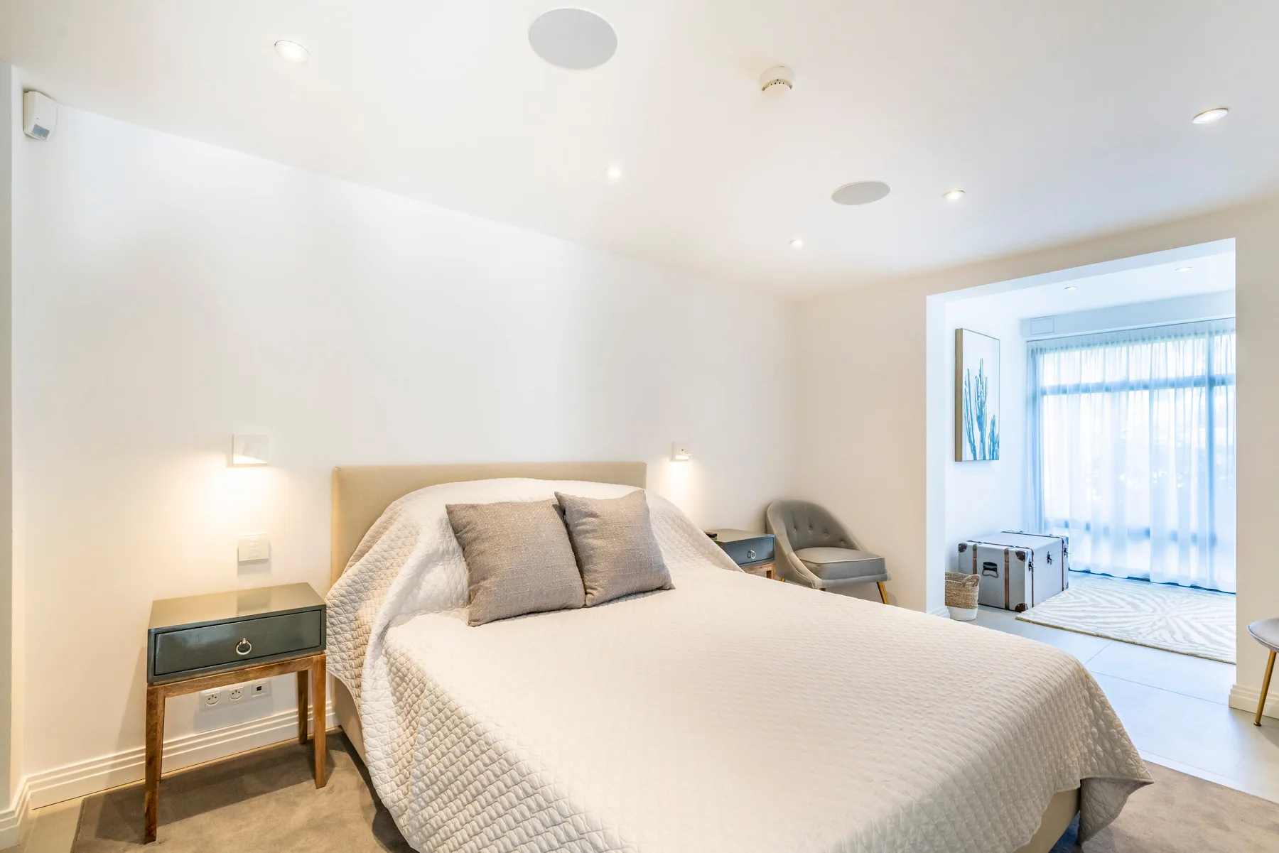 Suite invités avec coin salon, fauteuils et accès direct au jardin