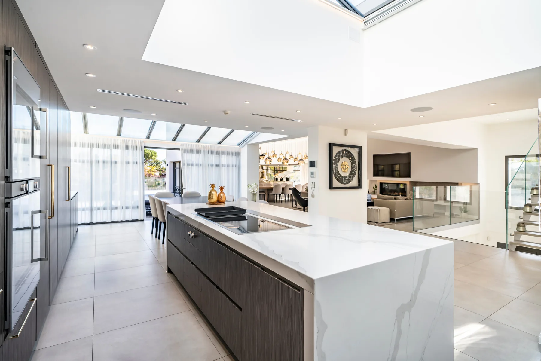 Master suite avec grand lit, TV mural et baies vitrées sur jardin