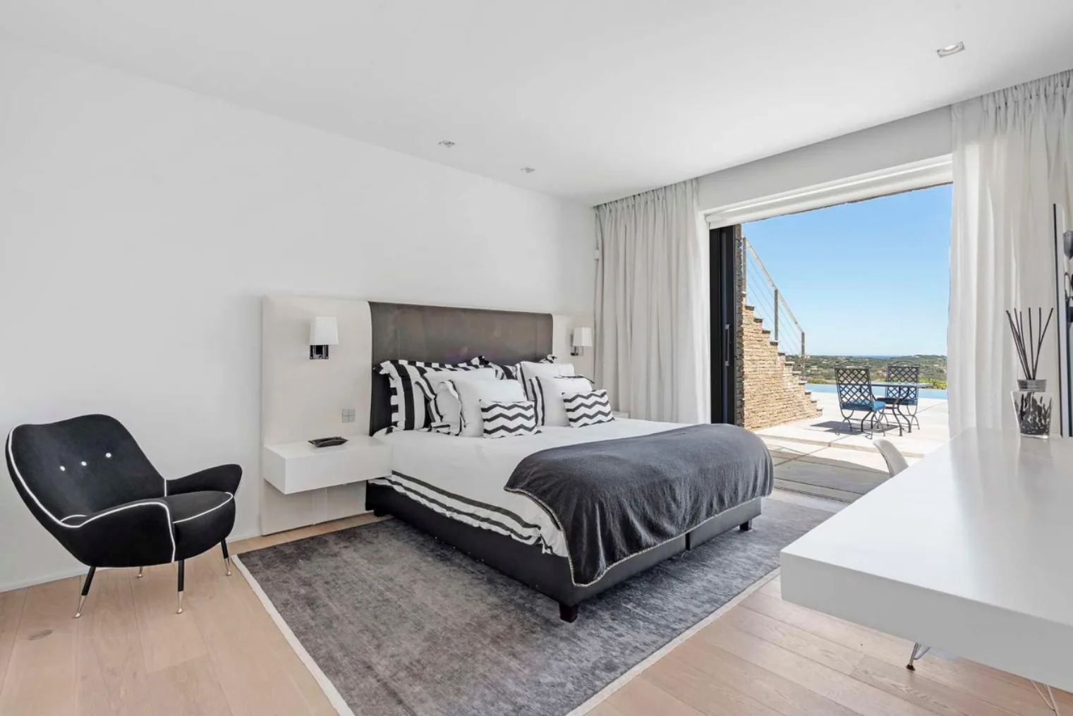 Chambre tons gris vue piscine et terrasse