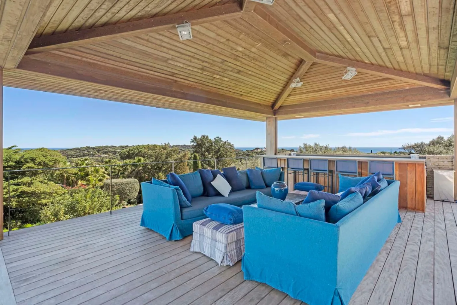 Terrasse couverte canapes bleus vue baie