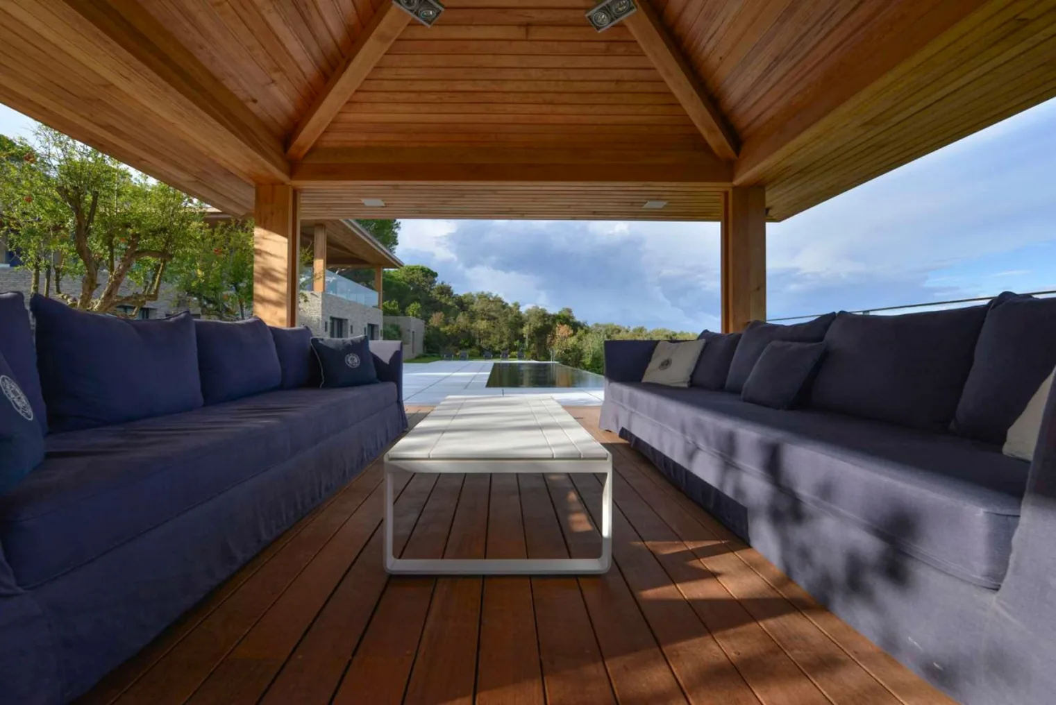 Pool house avec banquettes ecrues vue piscine
