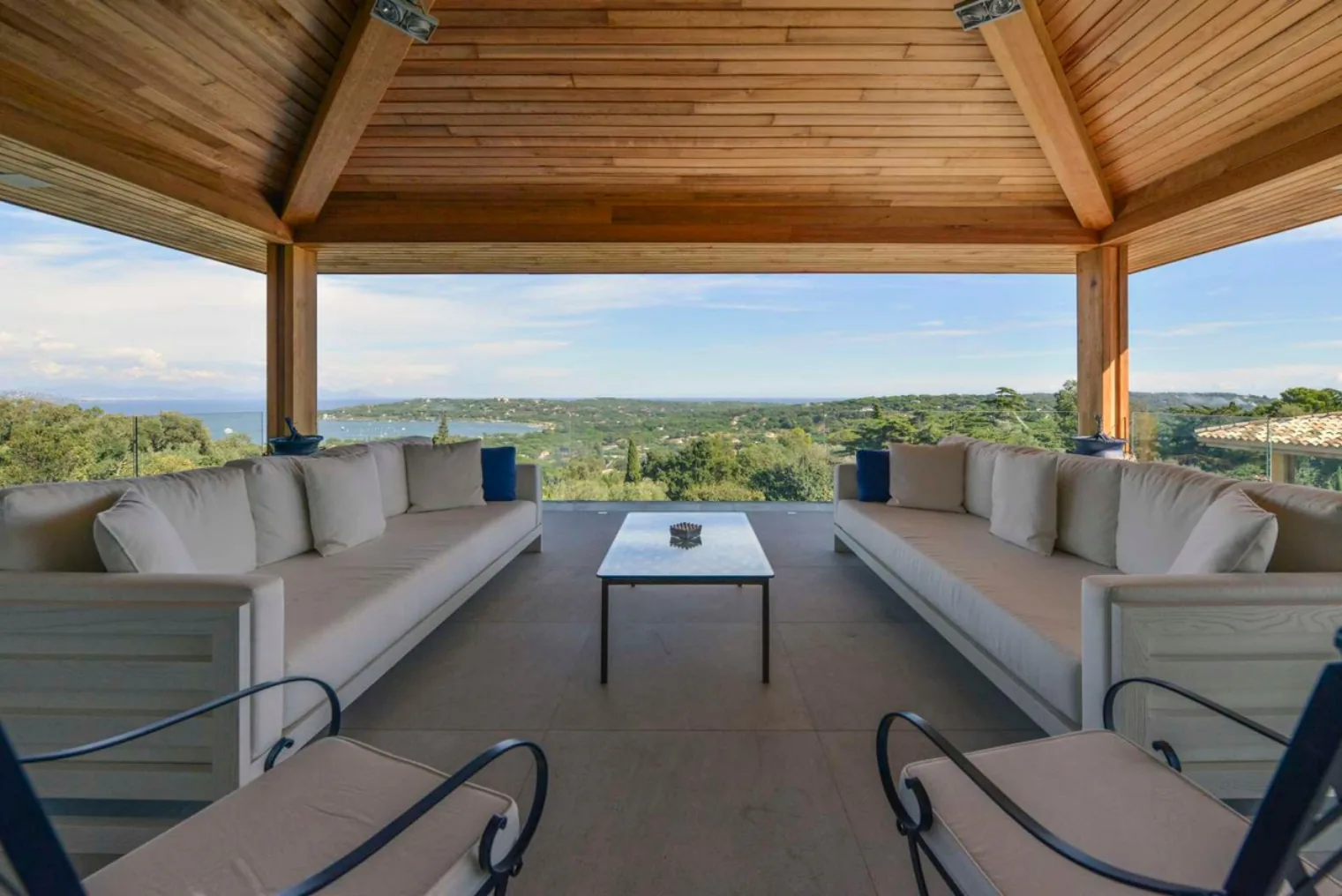 Salon exterieur ecru sous pergola vue baie