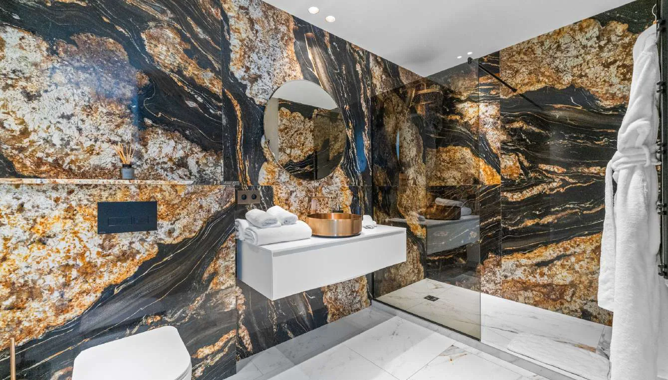 Salle de bain marbre or et noir avec vasque ronde et douche italienne