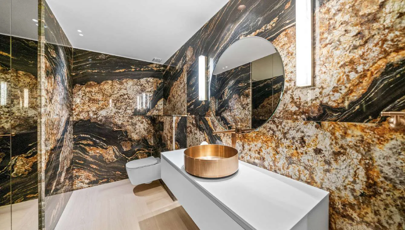 Salle de bain avec porte-serviettes en cuivre et baie vitrée vue mer