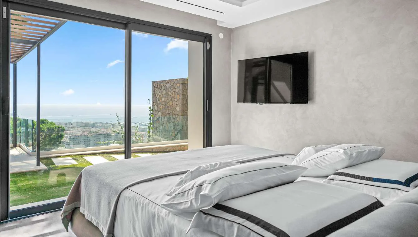 Suite invités avec banquette verte, TV et dressing verre