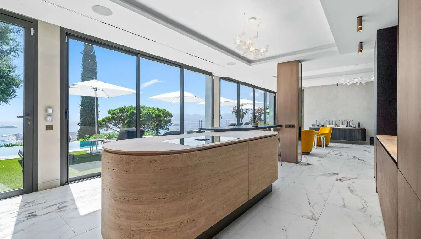Cuisine ouverte sur la terrasse et la piscine, marbre Calacatta au sol