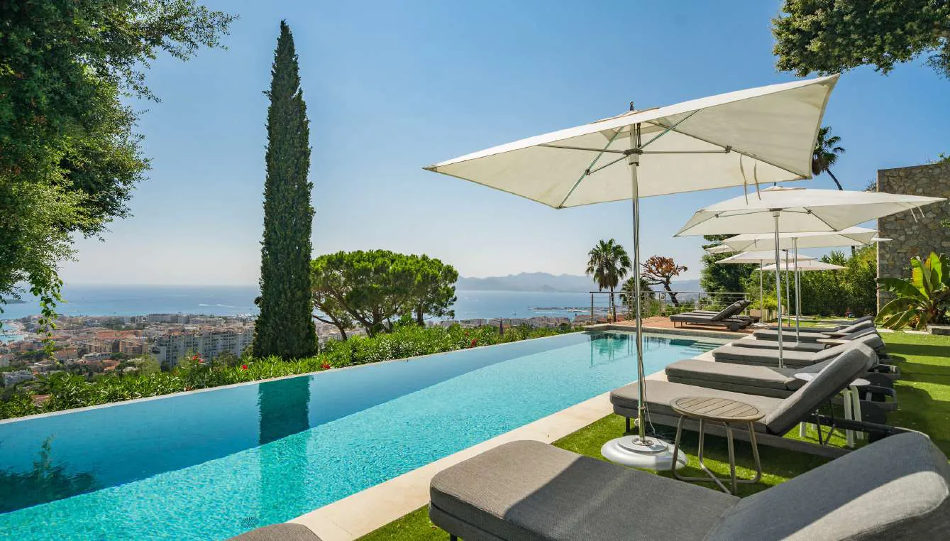 Bains de soleil sous parasols avec vue baie de Cannes et Cap d''Antibes