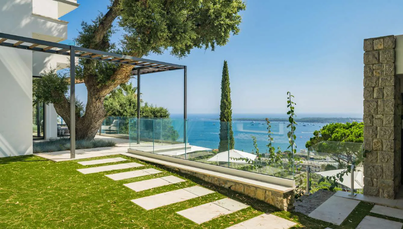Loungers blancs sur pelouse avec parasols autour de la piscine