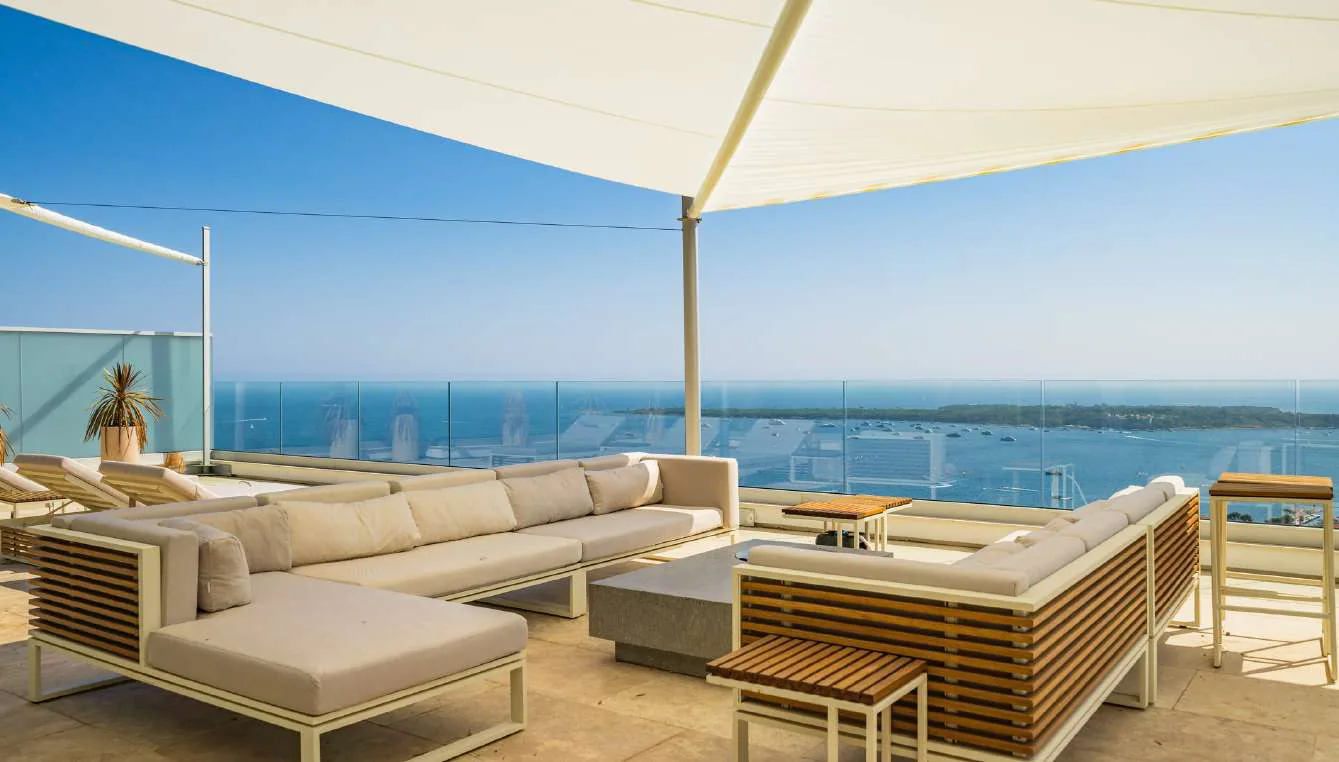 Rooftop avec canapés contemporains, table basse et vue baie de Cannes