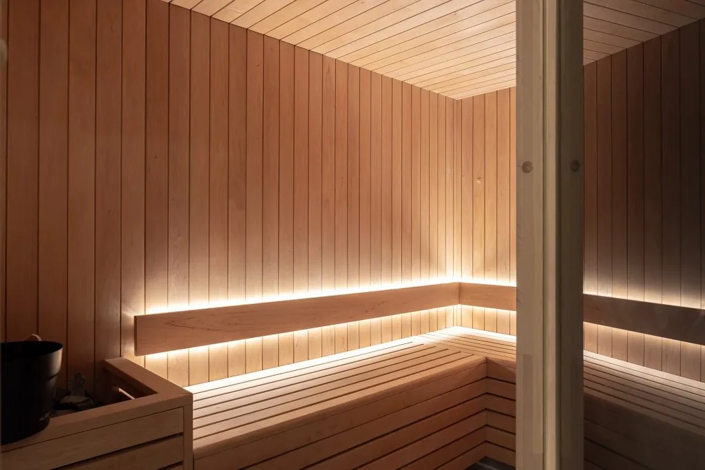 Sauna bois clair avec éclairage LED indirect et banquettes
