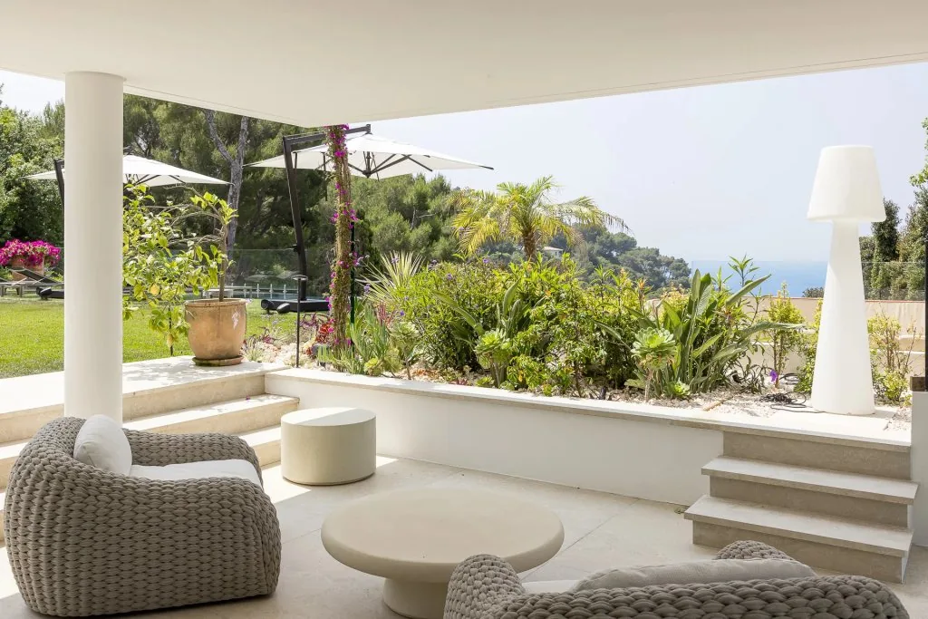 Terrasse couverte avec jardins paysagés, plantes méditerranéennes et vue mer