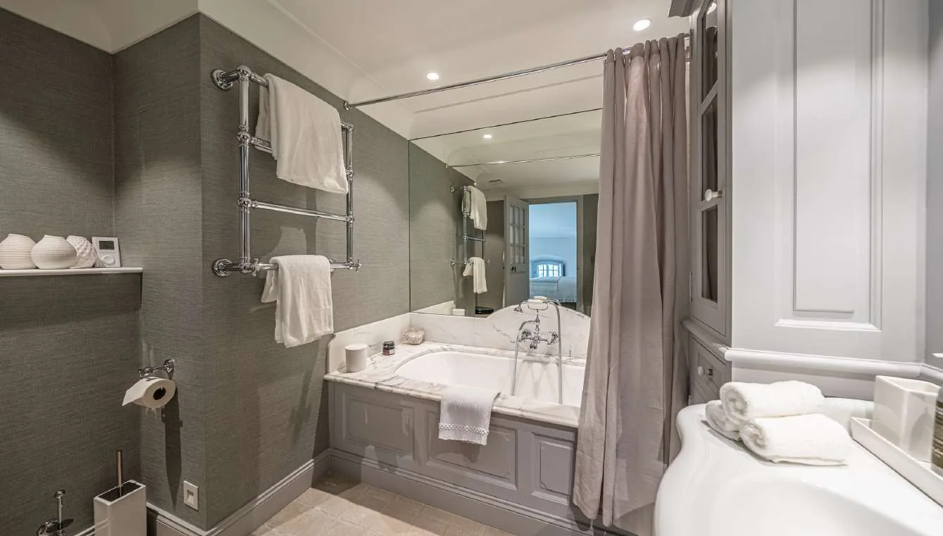 Chambre invites avec lit king, fauteuil et petite cheminee