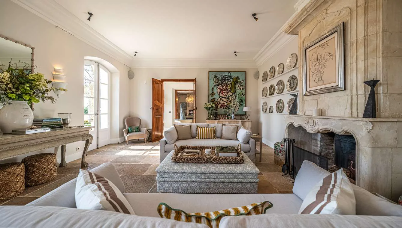 Salle a manger vue laterale avec lustre dore et chaises en rotin