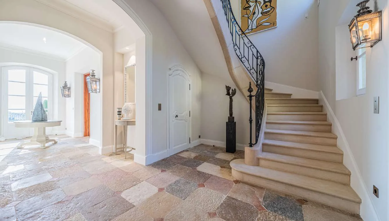 Hall d'entree avec double porte en bois sculpte et escalier en pierre