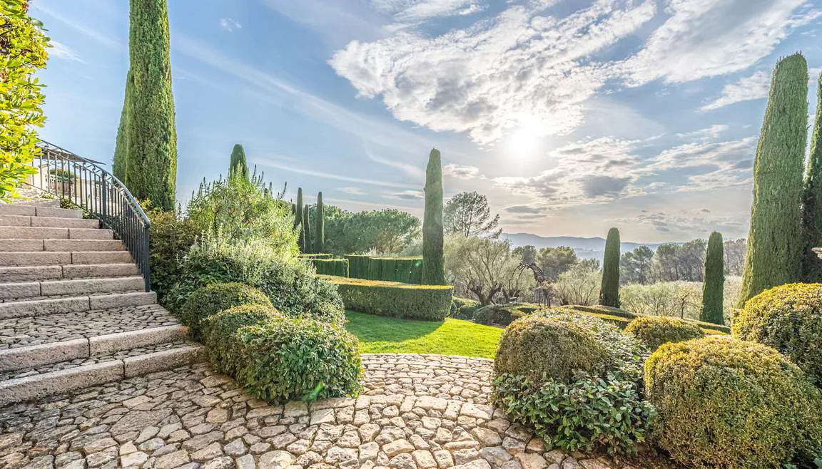 Vue sur le village de Mougins encadree par les cypres du jardin