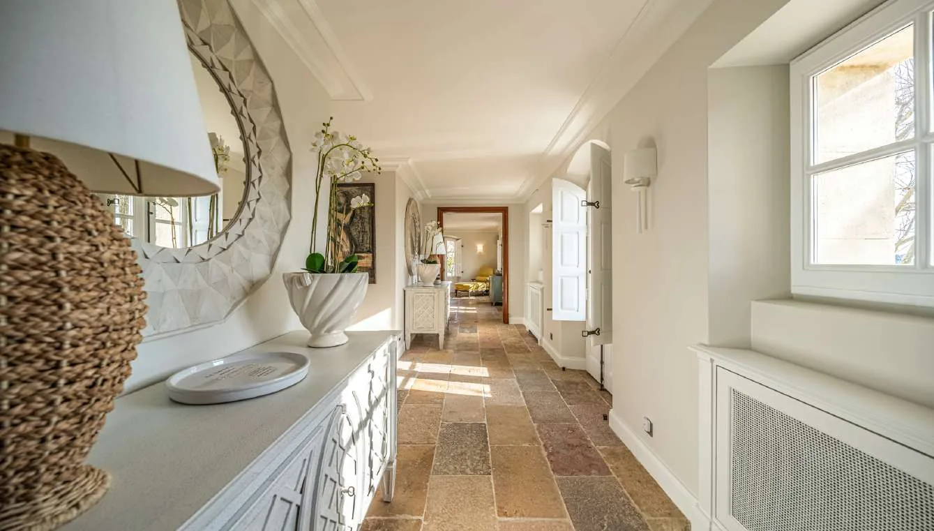 Couloir avec console blanche, miroir rond et orchidee blanche