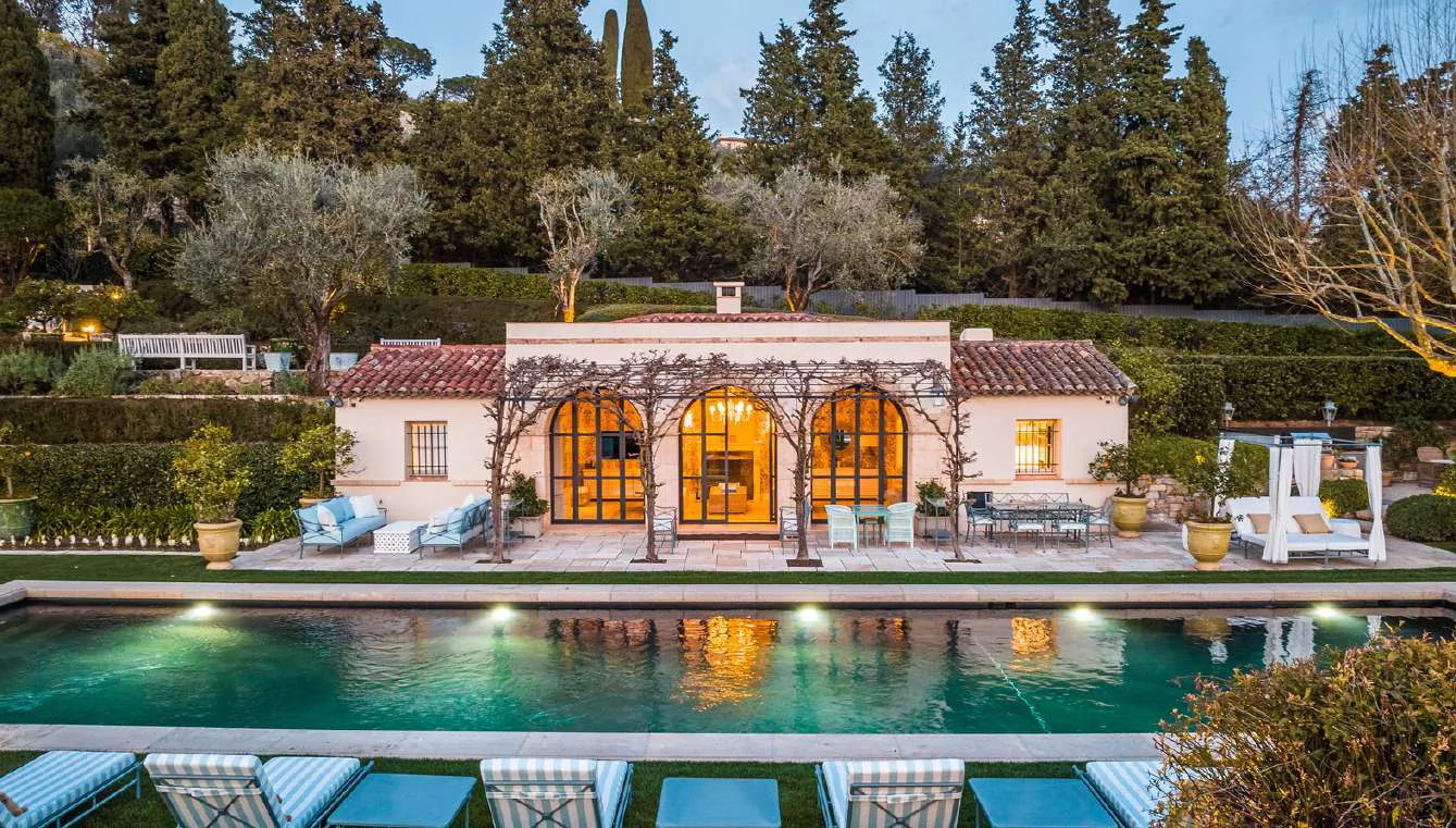Vue plongeante sur la piscine et le pool house au crepuscule
