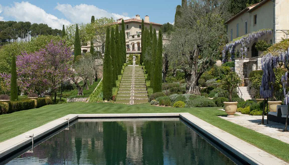 Pool house avec arches en glycine fleurie au printemps