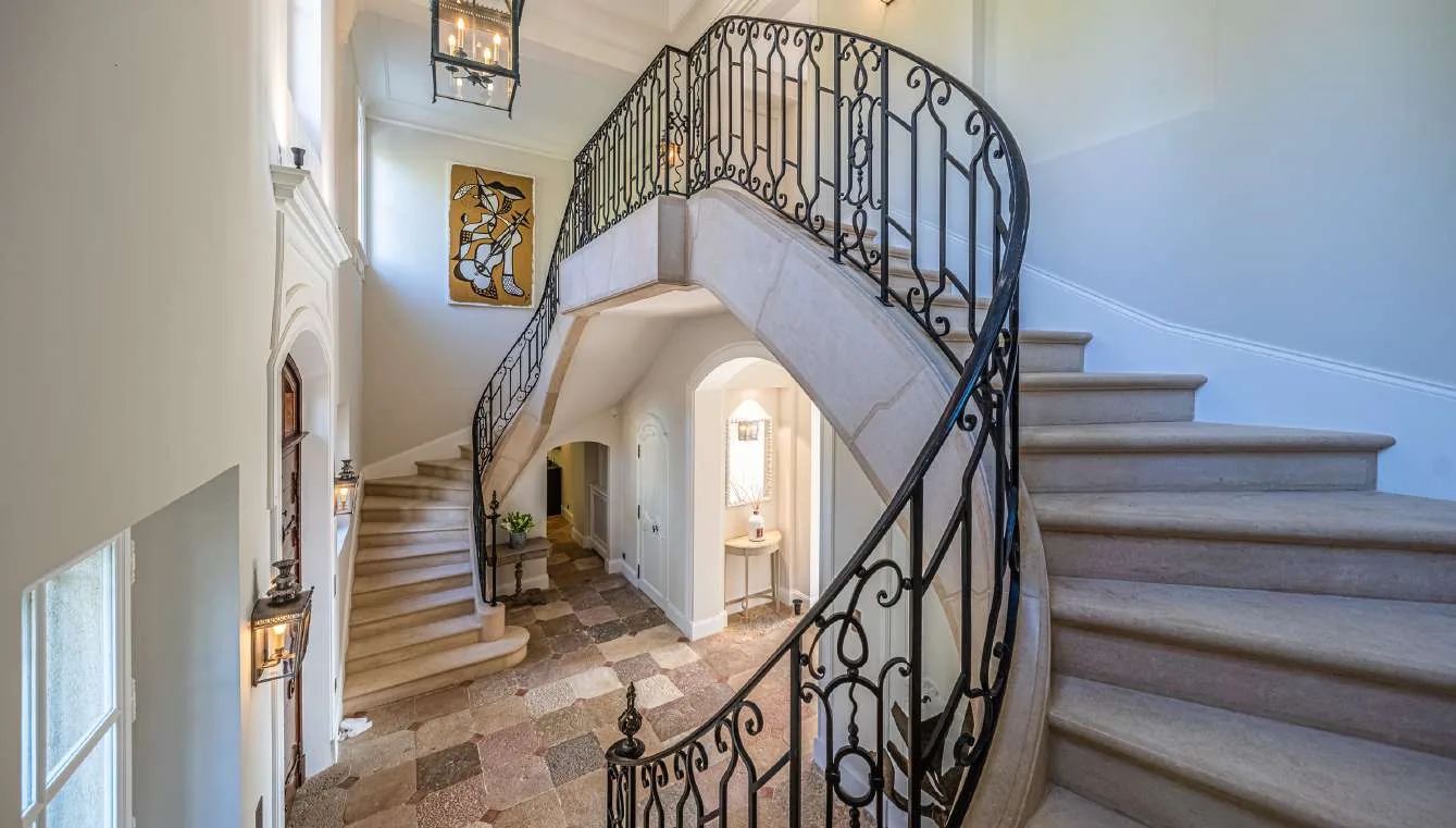 Vue depuis la mezzanine du grand escalier en pierre et ferronnerie