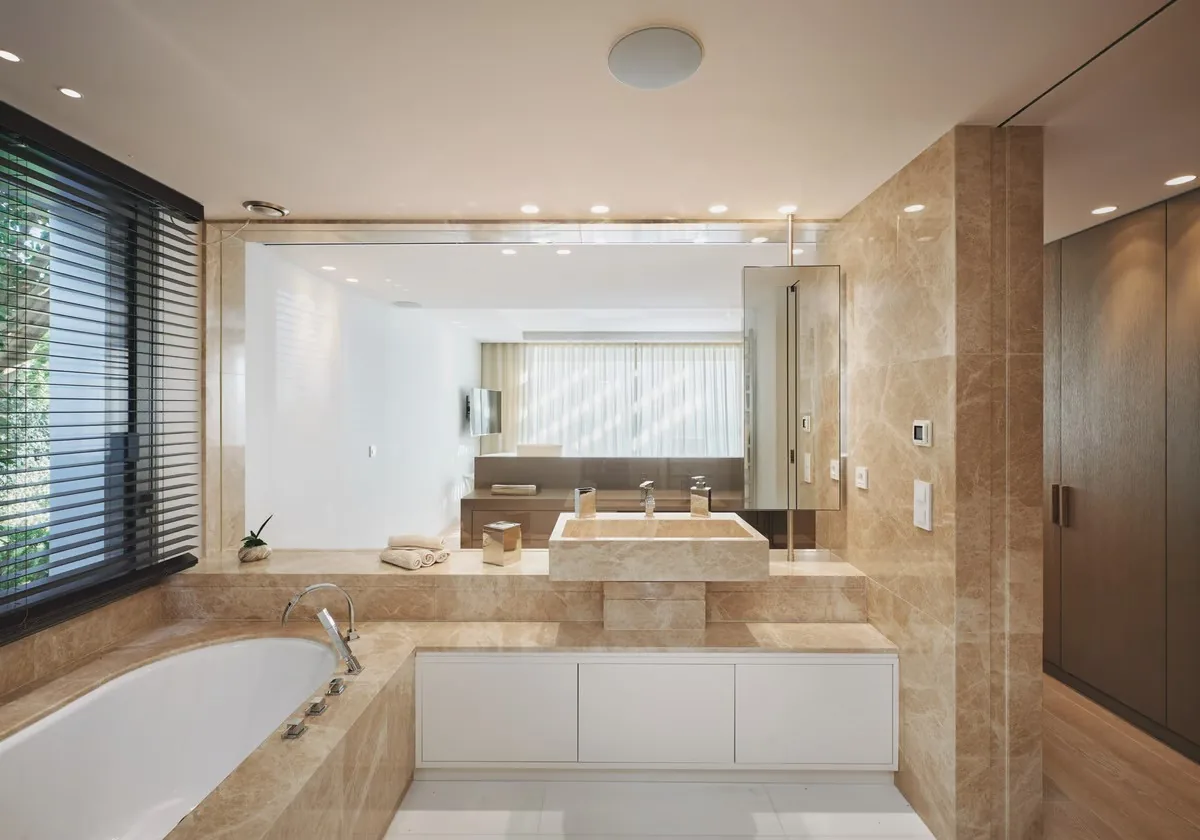 Salle de bain travertin avec baignoire et store horizontal