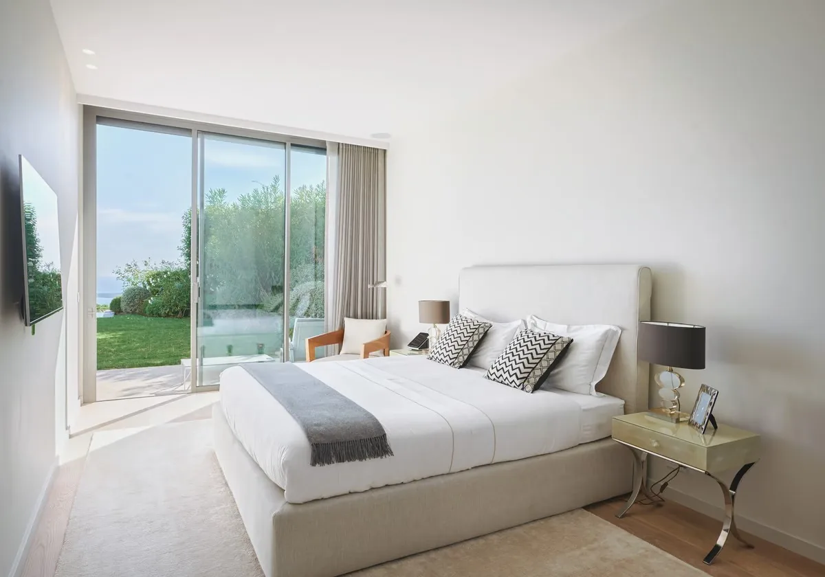 Chambre épurée tons blanc et gris avec coussins graphiques