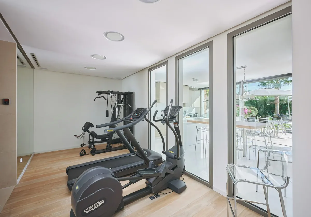 Salle de sport Technogym ouverte sur cuisine d'été
