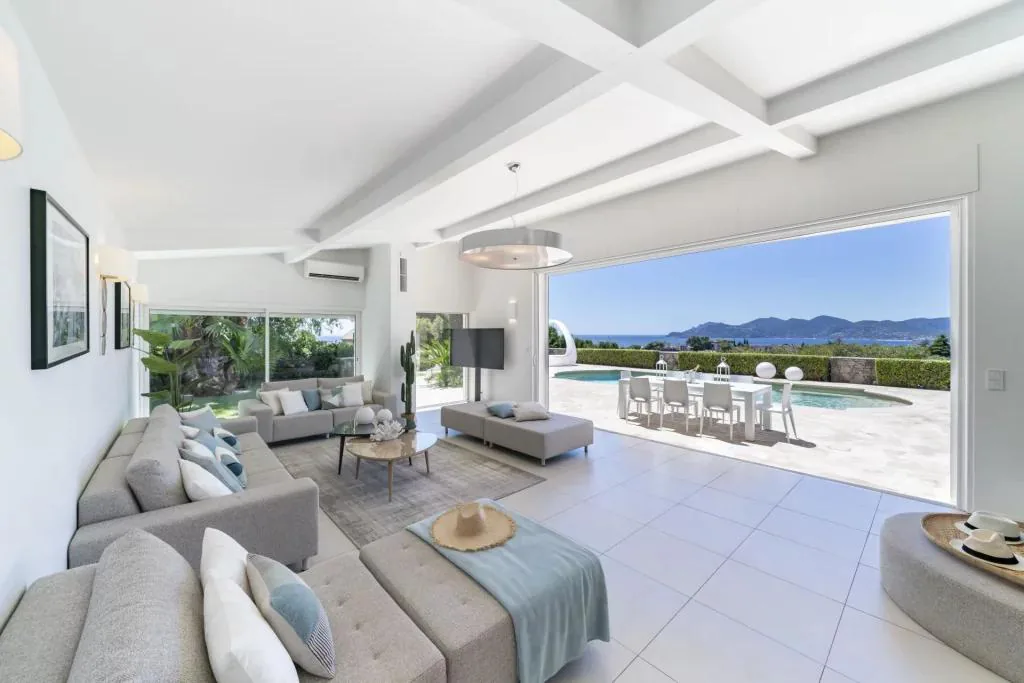 Salon ouvert plein sud avec baies coulissantes sur piscine