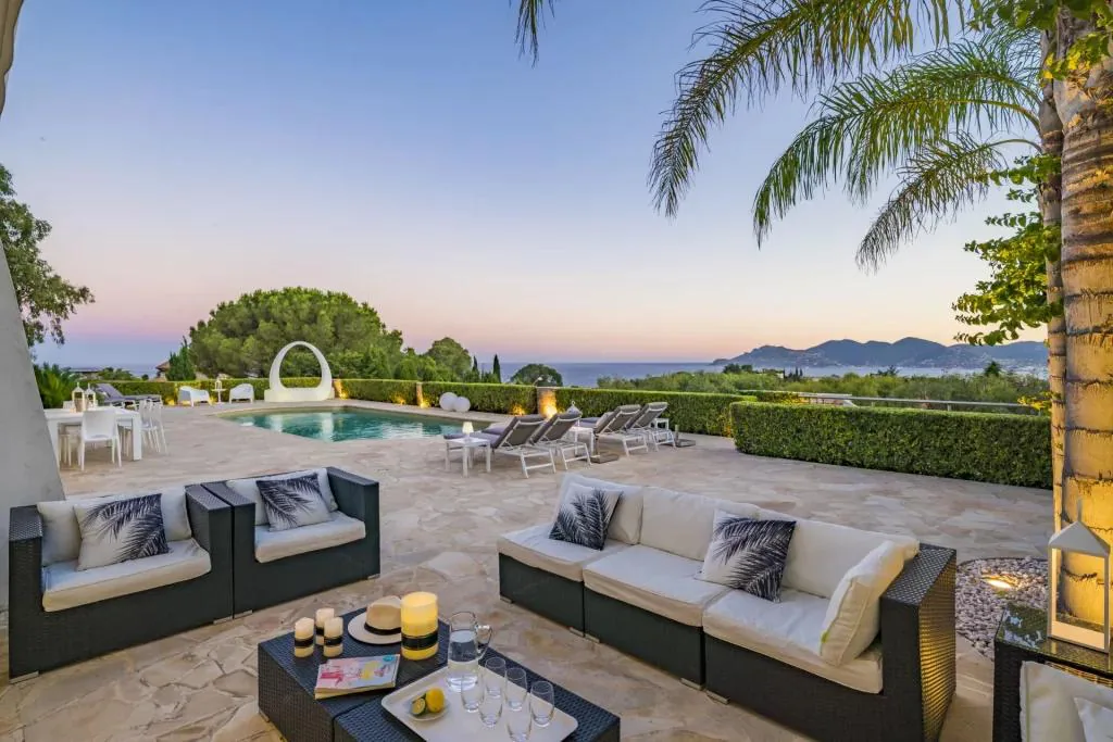 Terrasse au coucher de soleil et piscine vue mer