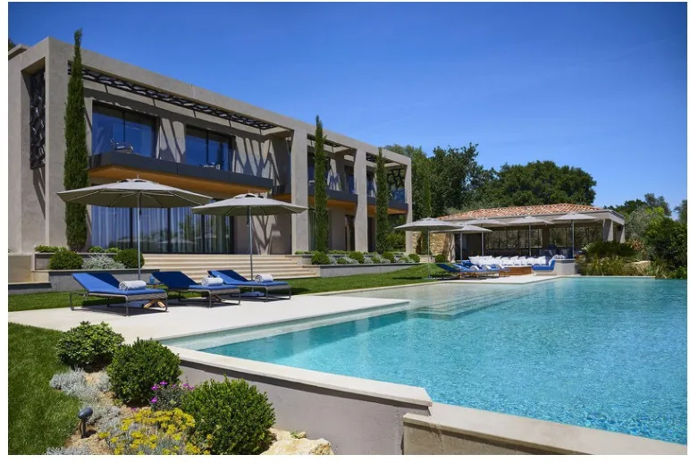 Façade contemporaine, piscine à débordement et bains de soleil