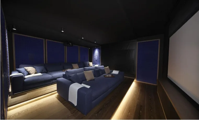 Salle de cinéma privée capitonnée bleu et grand écran