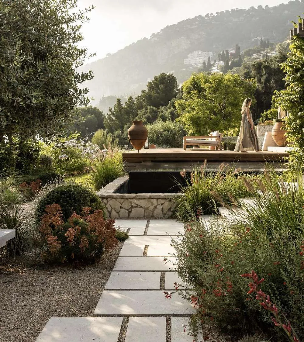Allée en pierre dans le jardin méditerranéen signé Jean Mus avec oliviers et jarres