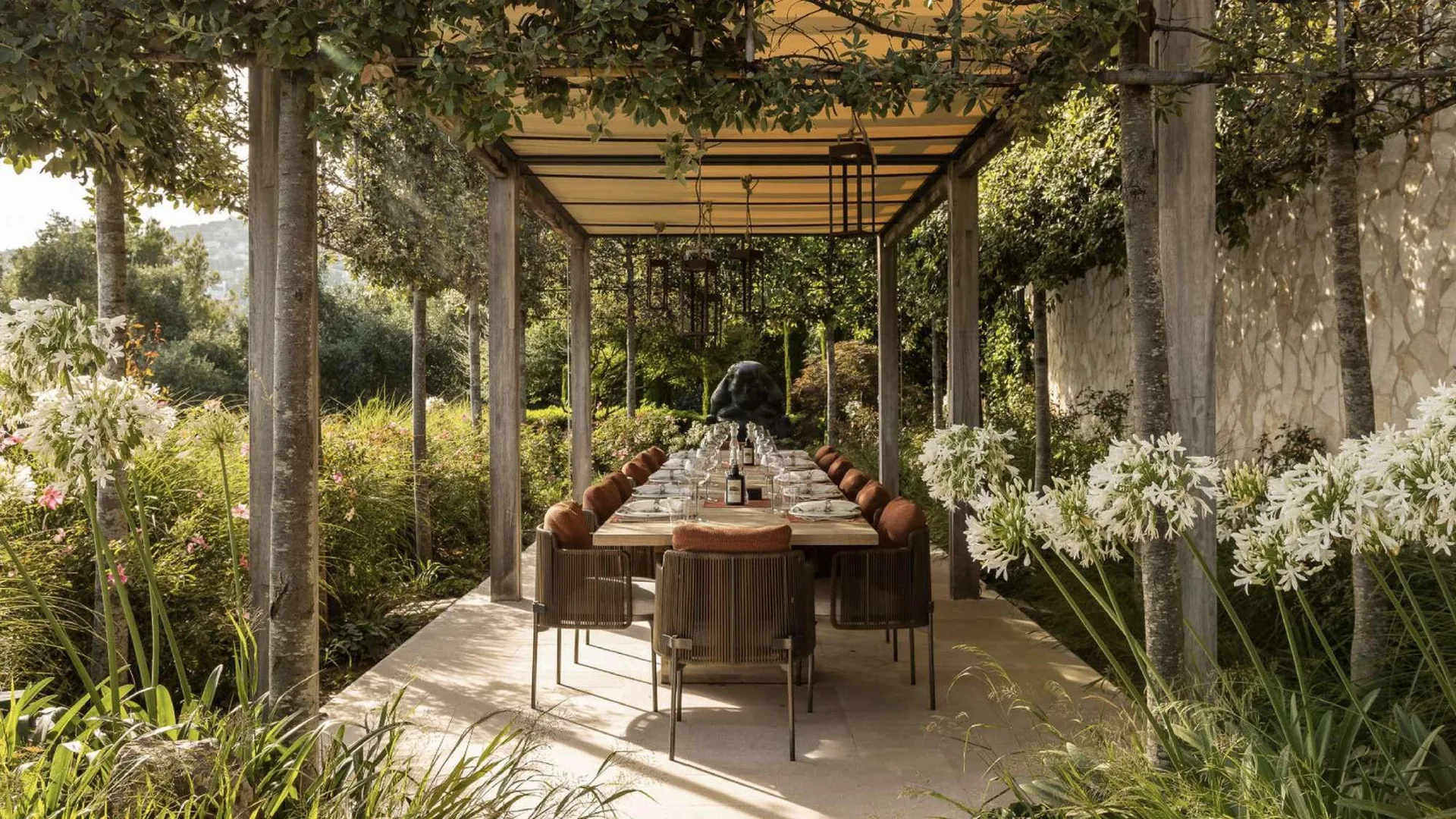 Pergola en bois avec longue table de salle à manger extérieure pour 14 convives et sculpture bronze